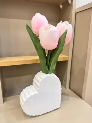 a white vase with pink flowers in it at Baannira บ้านนิรา in Ban Sam Kong