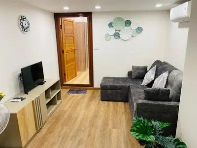 a living room with a couch and a television at Baannira บ้านนิรา in Ban Sam Kong