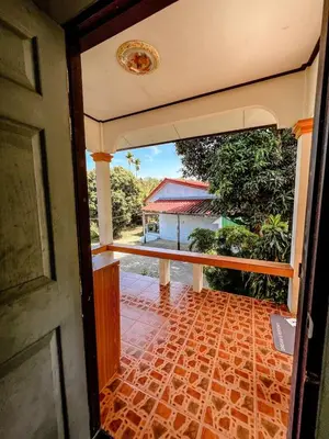 an open door of a house with a brick floor at Sea House in Panwa in Ban Lo Long