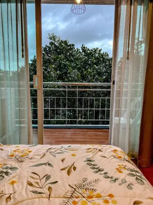 a bedroom with a bed and a large window at Green Place in Phuket Town