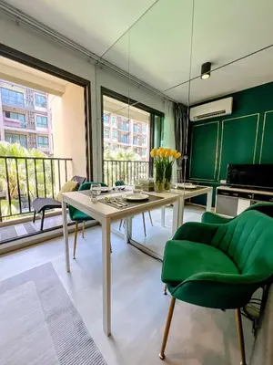 a dining room with a table and green chairs at Central Pool in Ban Lo Long