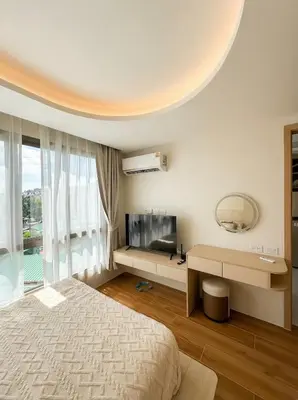 a bedroom with a bed and a flat screen tv at Fantasea Condo Kamala in Kamala Beach