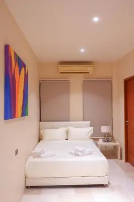 a bedroom with a white bed with a painting on the wall at Rare Sunrise Cliff Villa 5 Bedrooms in Ban Lo Ti Pa (1)