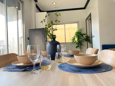 a dining room table with plates and glasses on it at Wink City 4 Patong Phuket in Patong Beach