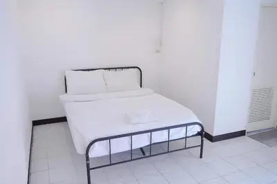 a bed with white sheets and pillows on it at XX GO INN Patong Beach in Patong Beach