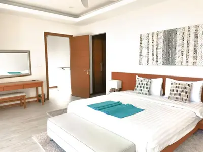 a bedroom with a large white bed and a piano at Rawai Beach Pool Villa 3 bedrooms in Rawai Beach