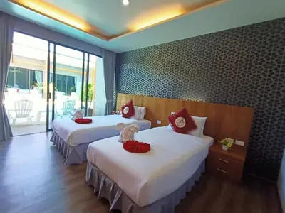 a hotel room with two beds with red pillows at Ohophuket in Phuket Town