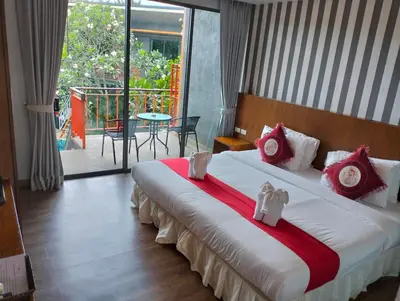 a bedroom with a large bed with red and white pillows at Ohophuket in Phuket Town