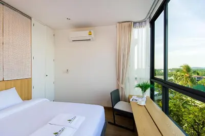 a bedroom with a bed and a large window at Condo Near Bangtao Muay Thai & MMA in Ban Thalat Choeng Thale