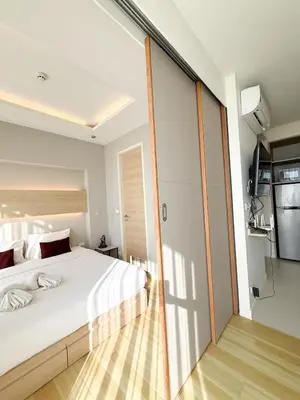 a bedroom with a large white bed and a glass wall at The Rocco pool view in Krabi town