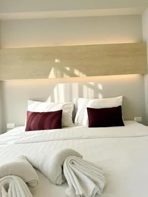 a large white bed with red pillows on it at The Rocco pool view in Krabi town