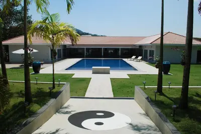 a pool with a sign in the middle of a yard at Villa Tha Maphrao in Ban Pa Khlok