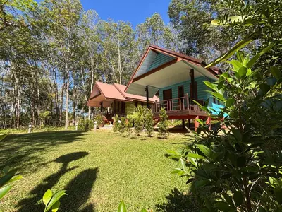 a small green house with a grass yard at Abir Homestay Koh Yao Yai in Ban Phlu Nai