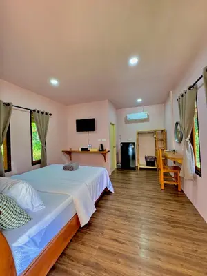 a bedroom with a large bed and a desk at Abir Homestay Koh Yao Yai in Ban Phlu Nai