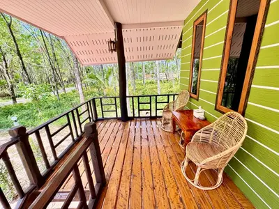a porch with a table and chairs on a house at Abir Homestay Koh Yao Yai in Ban Phlu Nai
