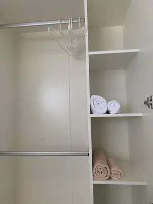 a closet with white walls and shelves with towels at 9169SiriplaceAirport in Ban Muang Mai (1)