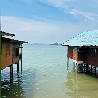 two houses on stilts in the water at Lamsai AC Sea House Green in Ko Yao Noi