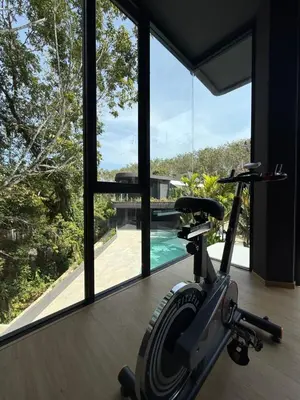 a gym with a exercise bike in front of a window at Villa Aileen Naithon in Nai Thon Beach