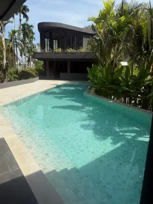 a swimming pool in front of a house at Villa Aileen Naithon in Nai Thon Beach