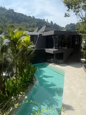 a house with a swimming pool in front of a house at Villa Aileen Naithon in Nai Thon Beach