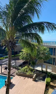 a view of a resort with palm trees and a pool at Sea View & Pool Apartment in Phuket Town