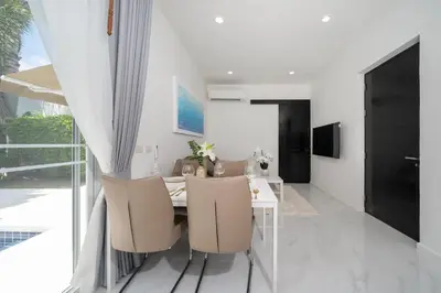 a dining room with a white table and chairs at The Greens Phuket Villa with swimming pool 18 in Ban Saiyuan (1)