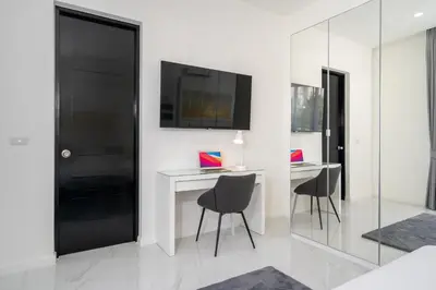 a room with a table and chairs and a black door at Brand New 3 Bedroom Pool Villa 18 in Ban Saiyuan (1)