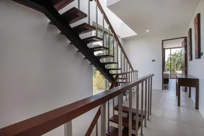 a spiral staircase in a house with a piano at Modern Comfort in Paradise - Villa Argent 6 with 3BR and Access to Tropical Pool in Thalang
