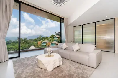 a living room with a white couch and large windows at Penthouse Luxurious Seaview Patong in Patong Beach