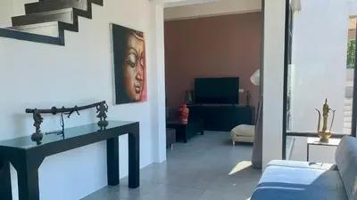 a living room with a table and a painting on the wall at Villa Loma 3 Chambres in Patong Beach