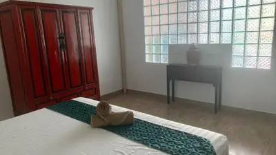 a bedroom with a bed and a red cabinet and a desk at Villa Loma 3 Chambres in Patong Beach