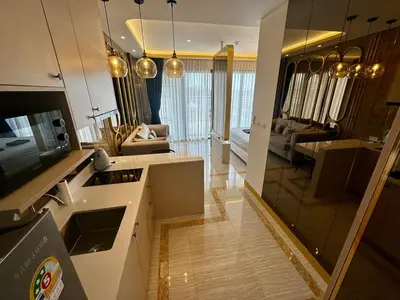 a kitchen and living room with a large mirror at Bellevue Lagoon Phuket in Laguna Phuket