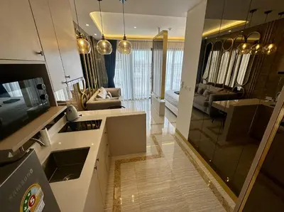 a kitchen and living room with a large mirror at Bellevue Lagoon Phuket in Laguna Phuket