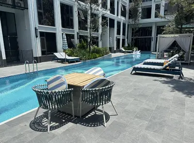 a table and chairs next to a swimming pool at Bellevue Lagoon Phuket in Laguna Phuket