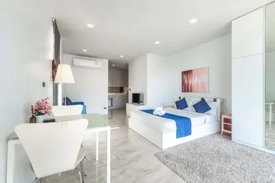 a bedroom with a white bed and a desk and a table at Vibrant Life at 4BR Pool Villa, Kata - UTK3 in Kata Beach