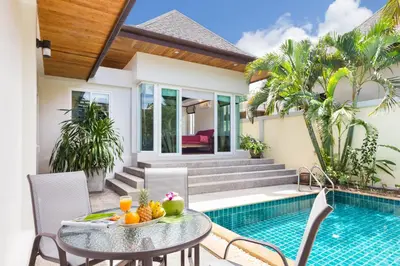 a patio with a table and chairs next to a swimming pool at Thai-Balinese Villa Alex in Rawai, 3BR, Private Pool in Rawai Beach