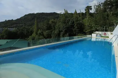 a large blue swimming pool with a mountain in the background at Fantasea Kamala 1 BR Apartments Near Beach 212 in Kamala Beach