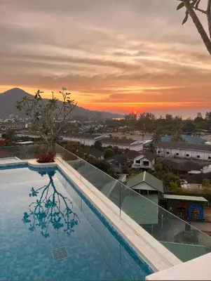 a swimming pool with a sunset in the background at Fantasea Kamala 1 BR Apartments Near Beach 212 in Kamala Beach