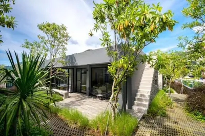 a modern house with glass walls and trees at Nature & Serenity - Exclusive Villa-Pavilion P06 in Natural Park Residence near Kamala Beac in Kamala Beach