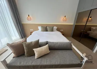 a bedroom with a large bed and a couch at 202 HOUSE near Bangtao Muay Thai & MMA in Ban Thalat Choeng Thale