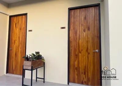 a room with two wooden doors and a table at 202 HOUSE near Bangtao Muay Thai & MMA in Ban Thalat Choeng Thale