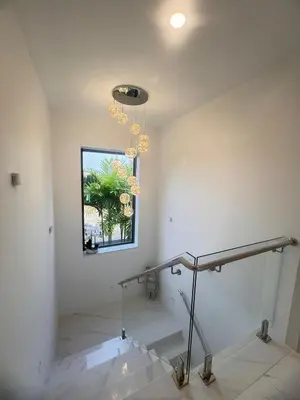 a staircase in a building with a window and a chandelier at \u62c9\u53e4\u5a1c\u9ad8\u5c14\u592b\u4ff1\u4e50\u90e8\u522b\u5885 in Ban Nong Chaeng