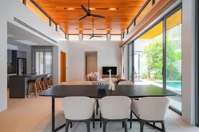 a dining room and living room with a table and chairs at 3BR Pool Villa at Botanica Modern Loft in Bangtao in Bang Tao Beach