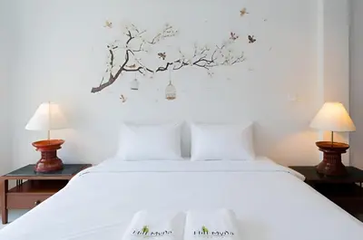 a bedroom with a white bed with two lamps at Apartments Near Bangtao Muay Thai & MMA in Ban Thalat Choeng Thale