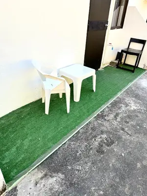 a white table and a chair on a green floor at Patong Canal Villa 107 in Patong Beach