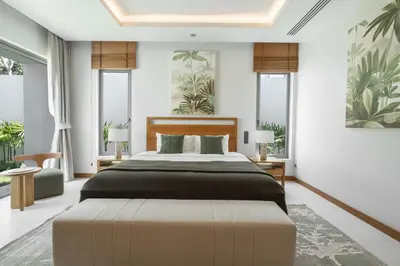a bedroom with a large bed with a large ottoman at Anchan Flora by Villacarte in Ban Phru Champa