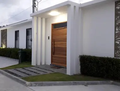 a white house with a wooden door on it at 01 - Beach Villa Retreat in Nai Yang Beach