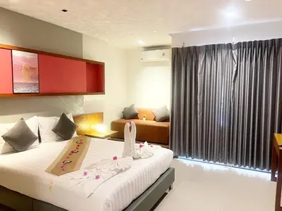 a hotel room with a bed with shoes on it at Arisa Hotel Patong Beach in Patong Beach