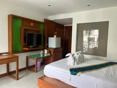 a bedroom with a bed with a tv and a table at Arisa Hotel Patong Beach in Patong Beach