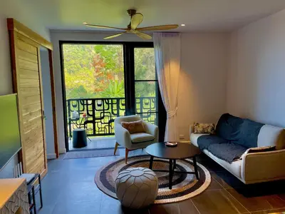 a living room with a couch and a table at Kata Luxury Apartment Matriochka 2BR En-suite in Kata Beach